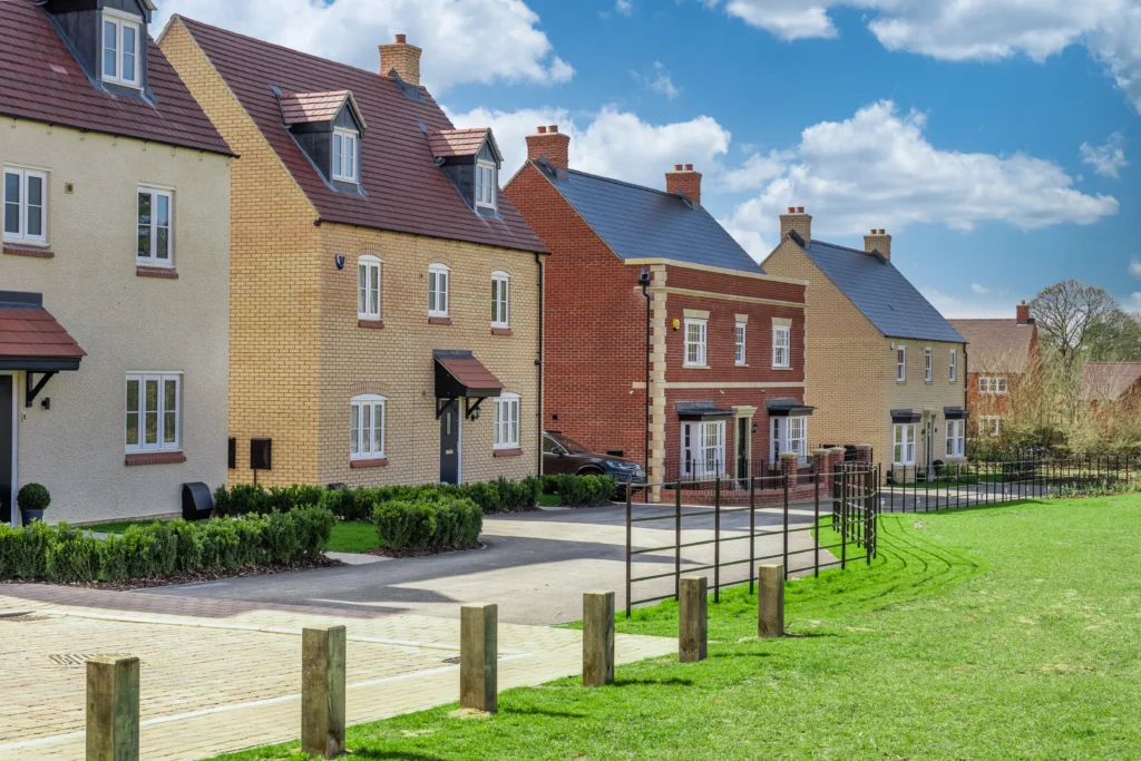 A row of four detached homes on a new Persimmon development, overlooking green space